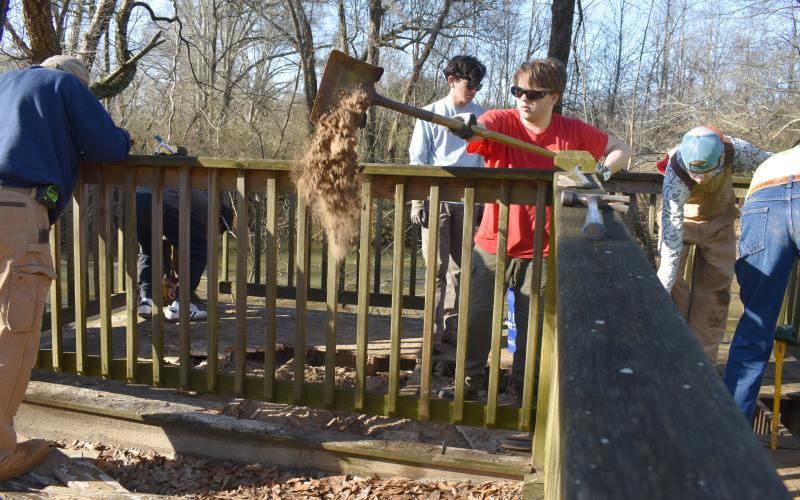 Cal Osborne shovels out dirt that’s collected under the boardwalk so he and his team of scouts and scout leaders can begin repairs on the boardwalk. SAMANTHA SINCLAIR/Staff