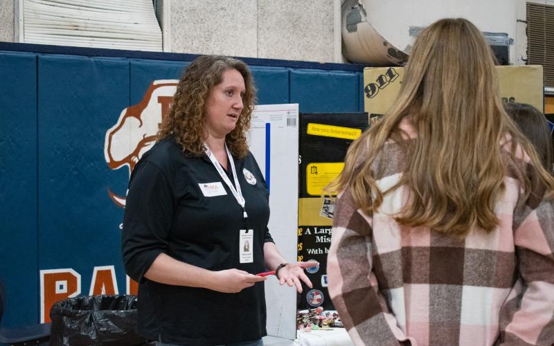 E-911 Dispatcher Kailey Gould starts a conversation with students interested in her line of work.  HANNAH CAUDELL/Staff