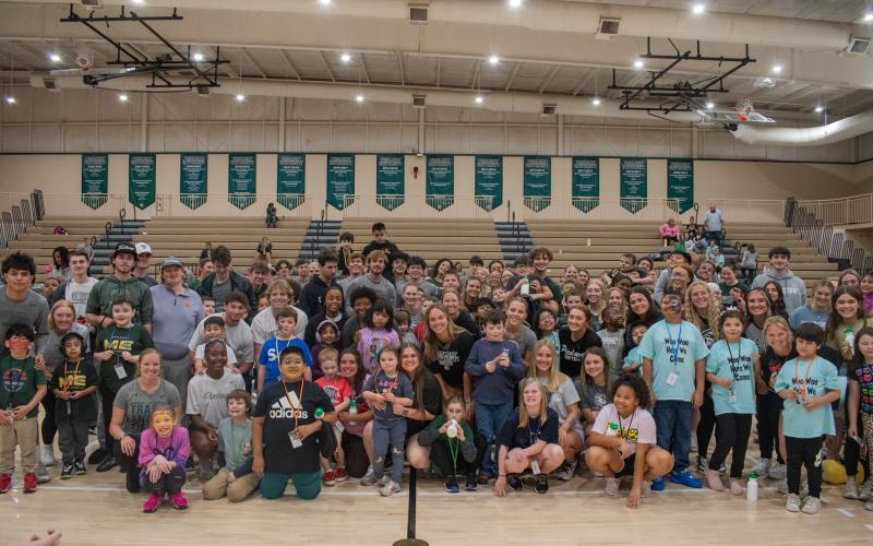 Elementary school students gather on the gym floor with their Piedmont University student “pals” for one last photo before the end of the games. The Piedmont students held a brief passing of the lanyard ceremony, welcoming the elementary schoolers in the Piedmont pride. HANNAH CAUDELL/Staff