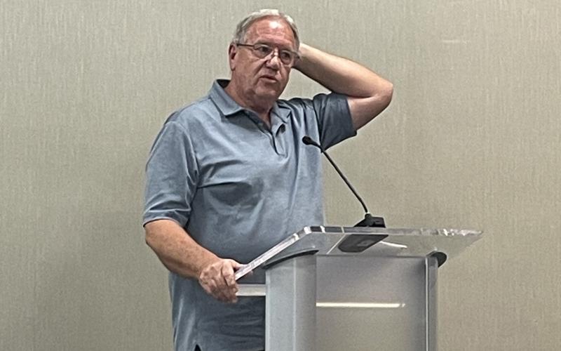 Dale Green stands at the podium to speak before the board on Thursday night to express his early concerns about the school system’s impending budget decision. HANNAH CAUDELL/Staff