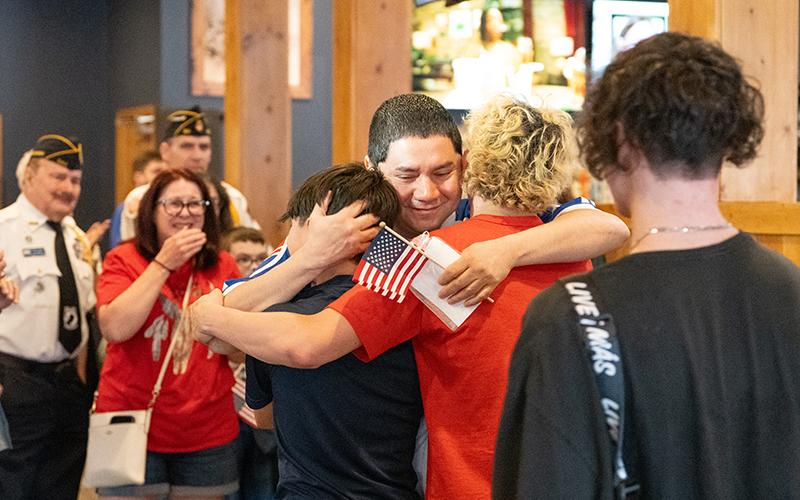 CWO-3 Jose Saravia hugs his sons, Eli Saravia, Christian Saravia and Gabe Lorenzo after surprising them at Bigg Daddy’s in Cornelia after being deployed for more than seven months. ZACH TAYLOR/Staff