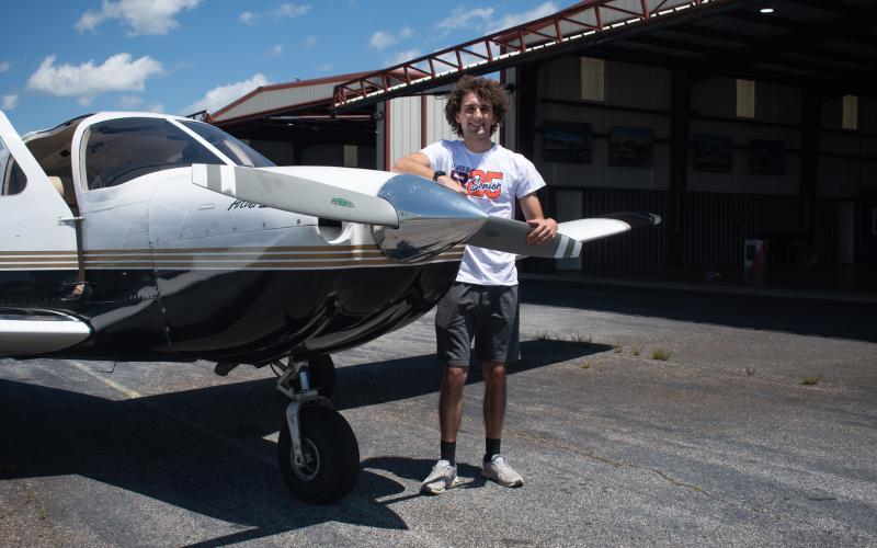 Habersham Central High School Senior Jackson Cribbs stands with one of the single engine planes he works with every day as a flight operations assistant at Horizon Dreams Aviation. After today’s graduation, Cribbs, who already holds an FAA private pilot license, will go on to study aviation at West Michigan University to be a professional aviation pilot. HANNAH CAUDELL/Staff