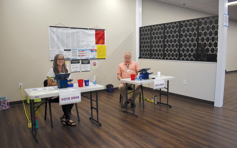 Assistant Poll Manager Stephanie Martin and Poll Manager Scott Brown wait for voters to check in at the Habersham County Elections and Voter Registration office in Cornelia. SAMANTHA SINCLAIR/Staff