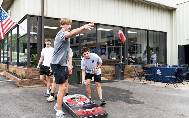 Habersham Central basketball stars and All-Regions pick Judge and Paris Wilbanks play cornhole at Crown Athletics’ grand opening ceremony on Saturday. ZACH TAYLOR/Staff