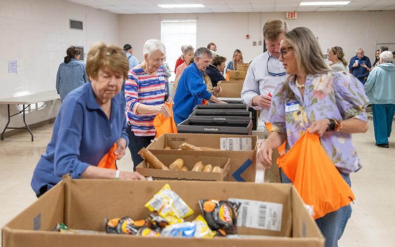 The folks from Food 4 Kids pack up some meals for kids in need in the Habersham County community. FILE