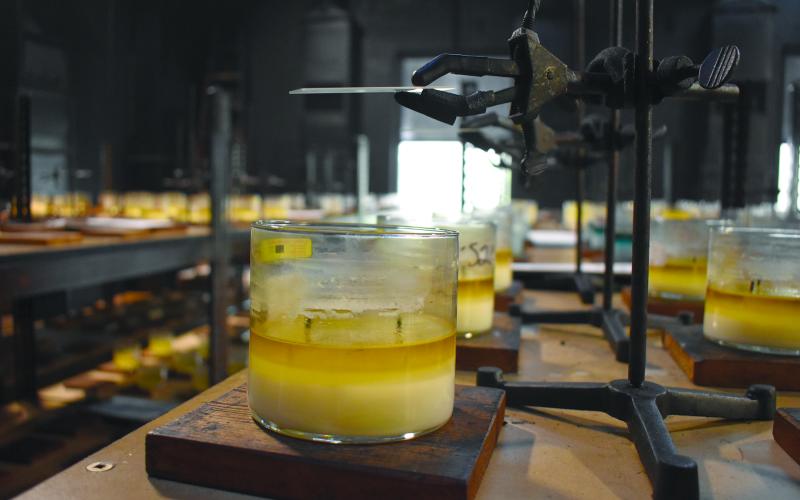 A piece of glass is suspended above a candle in the burn lab to test the amount of soot produced. Samantha Sinclair/Staff