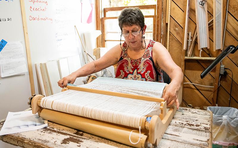 Gene Pease weaves on a heddle loom in the new AppalachianGap studio near the Art-Ful Barn’s new location off Ga. 17 in Clarkesville. ZACH TAYLOR/Staff