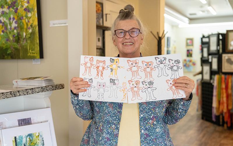 Local artist and illustrator Jan Walker holds up her summer class projects of kids’ animal cutouts. ZACH TAYLOR/Staff