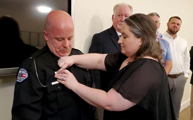 Clarkesville Officer Terry Lee Palmer is pinned with the Life Saving Award by his wife Samantha. (Samantha Sinclair/Staff)