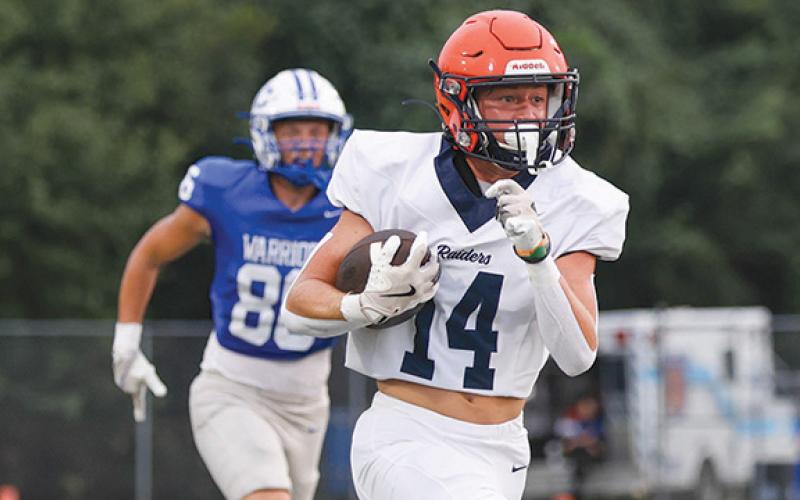 Habersham Central’s Sawyer Burgess (14) takes the ball to the house for a pick-6 during a scrimmage between Habersham Central and Oconee County at Oconee County High School on Friday, Aug. 1. The Raiders won 44-14. (Landen Todd/Staff)