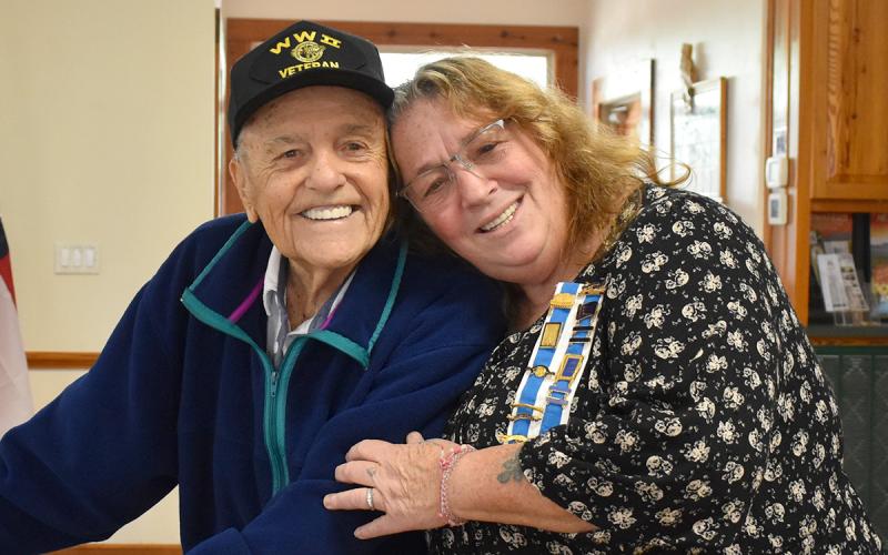 Tomochichi Chapter Regent Lynn McCollum (right) hugs World War II veteran Andy Negra during a special meeting honoring veterans. (Samantha Sinclair/Staff)