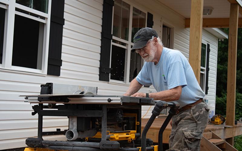 Habitat for Humanity volunteer John Ott cuts flooring to fit into one of the new Habitat homes on the Clarkesville property. Habitat for Humanity of Northeast Georgia is one of the housing nonprofits affected by the government shutdown, which ended Wednesday evening. (Hannah Caudell/Staff)