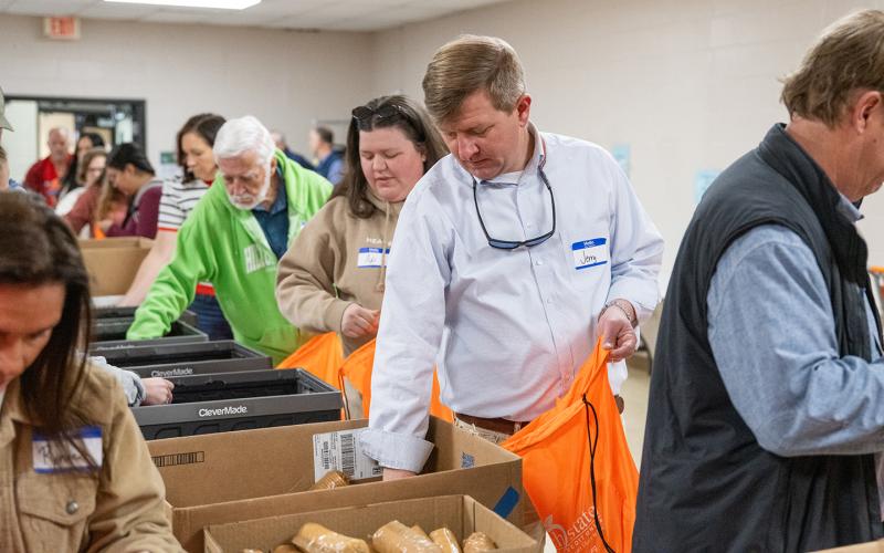 Demorest Mayor Jerry Harkness helps to pack bags of food for kids in Habersham County. The Everyday Good’s Food4Kids program volunteers packed food for Habersham County students for the Christmas break on Tuesday morning. (Zach Taylor/Staff)