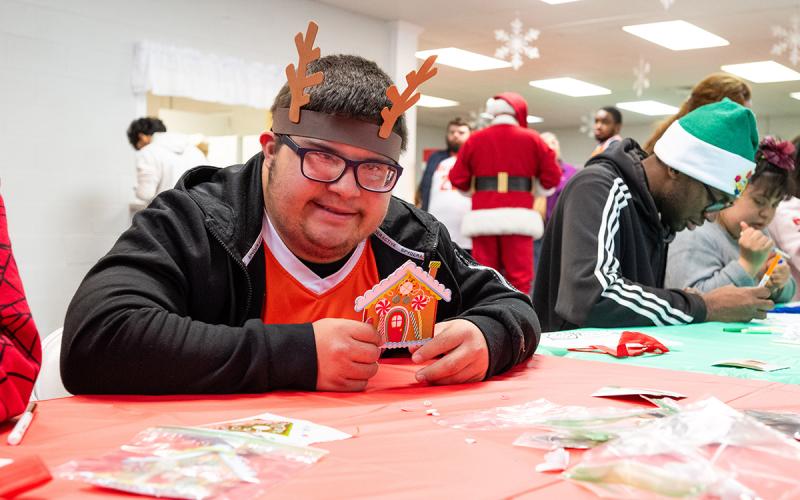 Ethan Ortiz proudly shows his colored gingerbread house at the Hillside Baptist Church Autism Christmas event. (Zach Taylor/Staff)