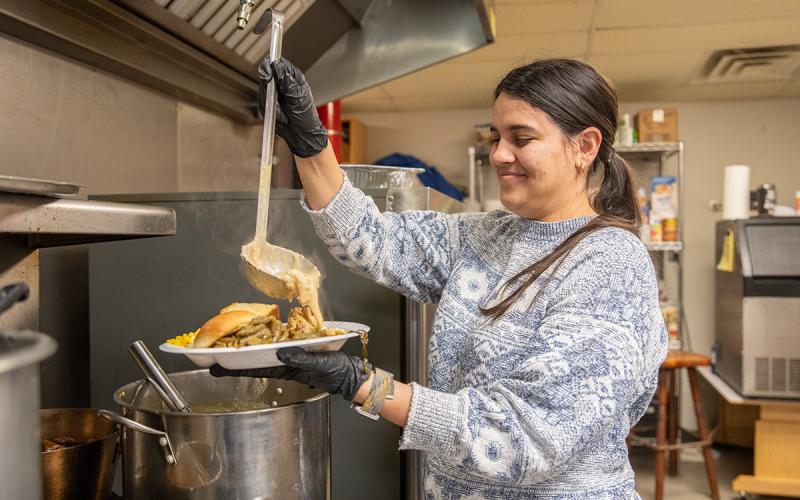 Cloe Carr pours gravy over a plate for guests of the soup kitchen in Cornelia. (Zach Taylor/Staff)