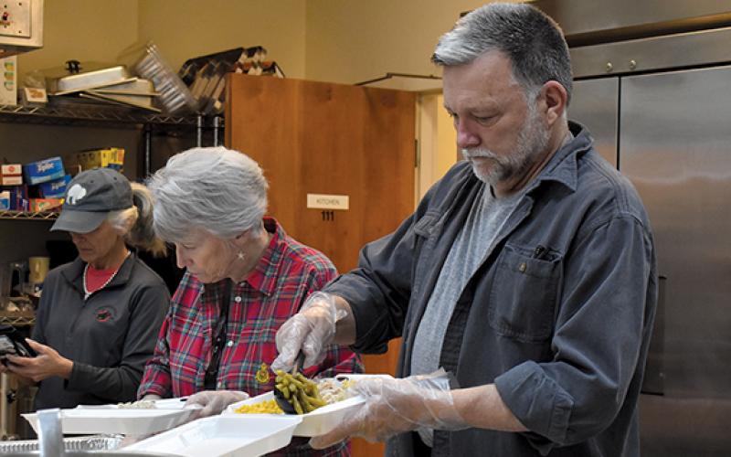 Claudia Jessup and Brant Finley work together to prepare meals at the First Presbyterian Church on Christmas Day. (Samantha Sinclair/Staff)