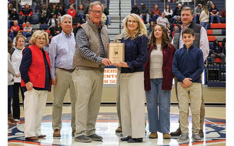 Left to right: Mother, Margaret Tench, husband, Stan Gunter, HCHS Athletic Director Geep Cunningham, Rita Tench Gunter, dad, Charles Tench (hidden), granddaughter Cayden, son Chase and grandson Westin pose during the basketball hall of fame ceremony at the Raider Gymnasium on Friday, Dec. 19. (Landen Todd/Staff)