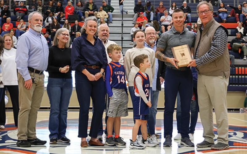 Left to right: Kevin Thurmond, Deborah Thurmond, Haley Queen, Kevin Boyce, Boyce Queen, Julian Queen, Jameson Caine, David Thomason, Sandi Thomason, Kevin Queen and HCHS Athletic Director Geep Cunningham pose during the basketball hall of fame ceremony at the Raider Gymnasium on Friday, Dec. 19. (Landen Todd/Staff)