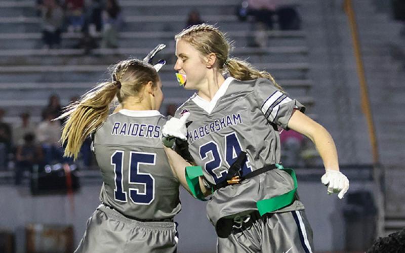 Habersham Central sophomore receivers Macy Huff (15) and Tessa Murdock (24) jump up in celebration during a flag football game at Raider Stadium on Wednesday, Nov. 19. (Landen Todd/Staff)
