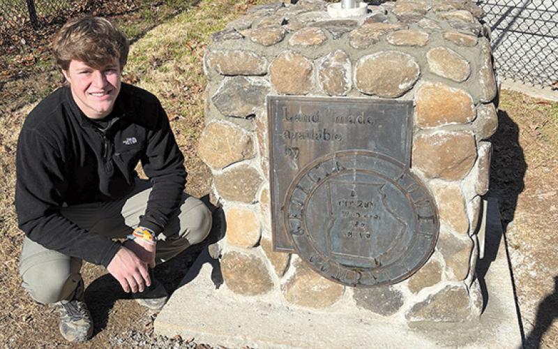 Sawyer Burgess proudly shows the completed stone pedestal with a bronze plaque noting the land for the Lake Burton Fish Hatchery was provided by Georgia Power. (Submitted)
