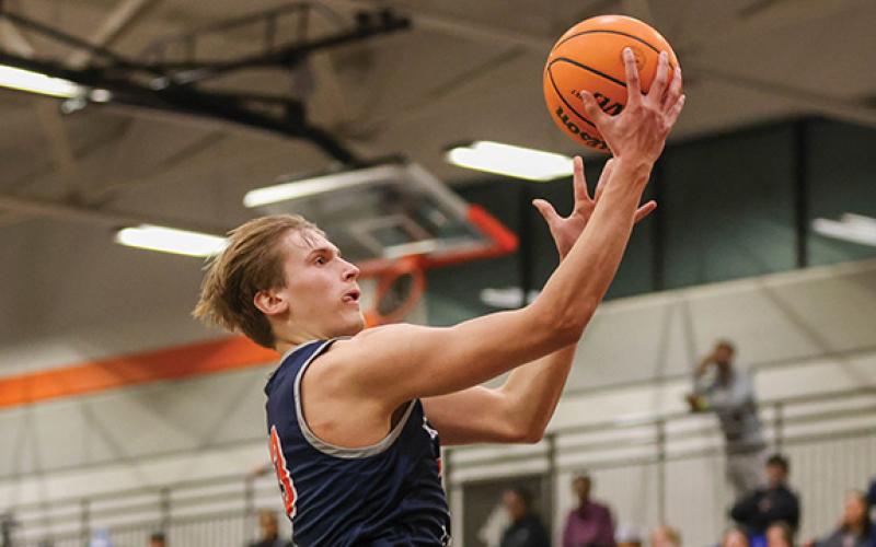 Left, Habersham Central senior forward Judge Wilbanks (13) goes up for a basket during the Mcdonald’s Shootout final at Hart County High School on Tuesday, Dec. 30. Right, Habersham Central junior guard Micah Huff (1) pumps his fist in celebration during the McDonald’s Shootout final. (Landen Todd/Staff)