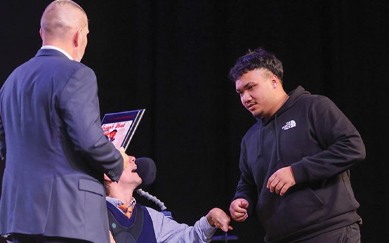 Habersham Central senior lineman Andru Kinnarath fists bump Coach Joseph York during the Habersham Football Banquet. (Landen Todd/Staff)