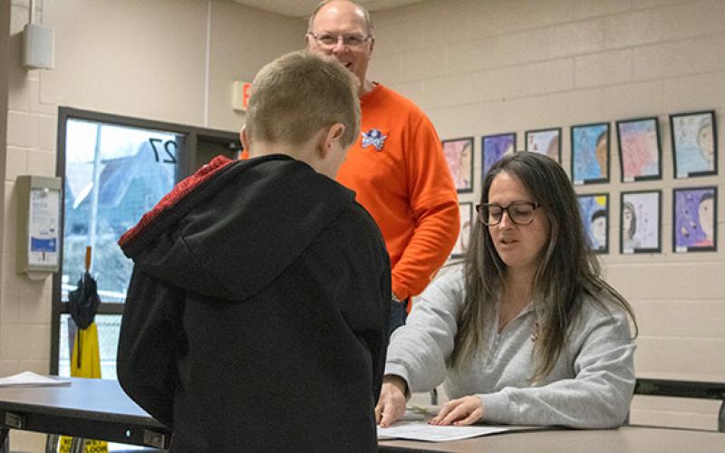 Baldwin Elementary Assistant Principal Alexandria Noggle hands packets out to students on Friday, Jan. 30 ahead of a new winter weather system after the county just recovered from Winter Storm Fern. (Hannah Caudell/Staff)