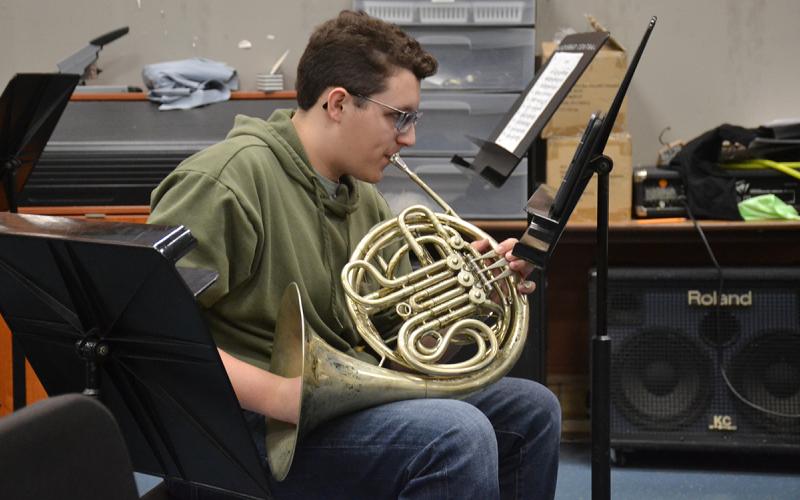 Christian Moore practices playing the French horn during band class at Habersham Central High School on Wednesday. (Samantha Sinclair/Staff)