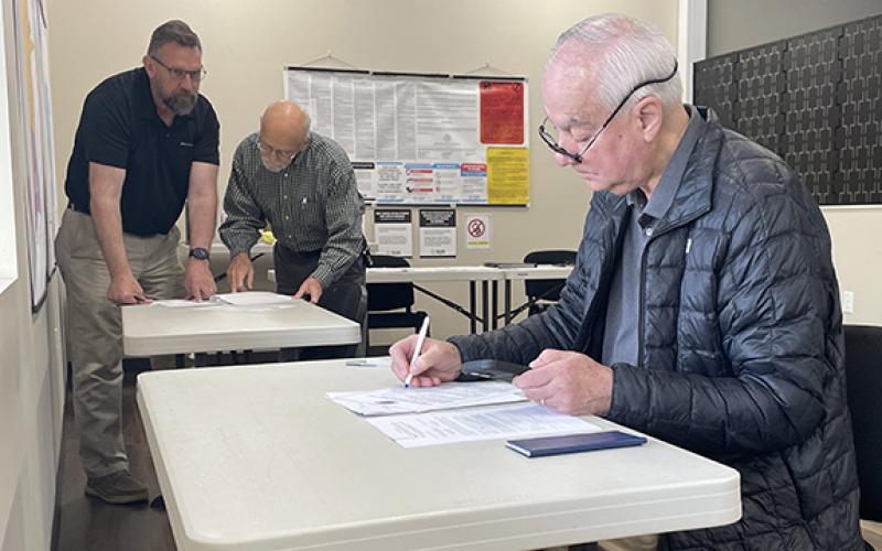 Joey Duncan fills out paperwork to run for reelection for the Habersham County Board of Education District 5 seat while Habersham County Board of Commissioners District 3 candidate Jason Smith talks with Habersham County Republican Party representative Jim Ferraro in the background. (Hannah Caudell/Staff)
