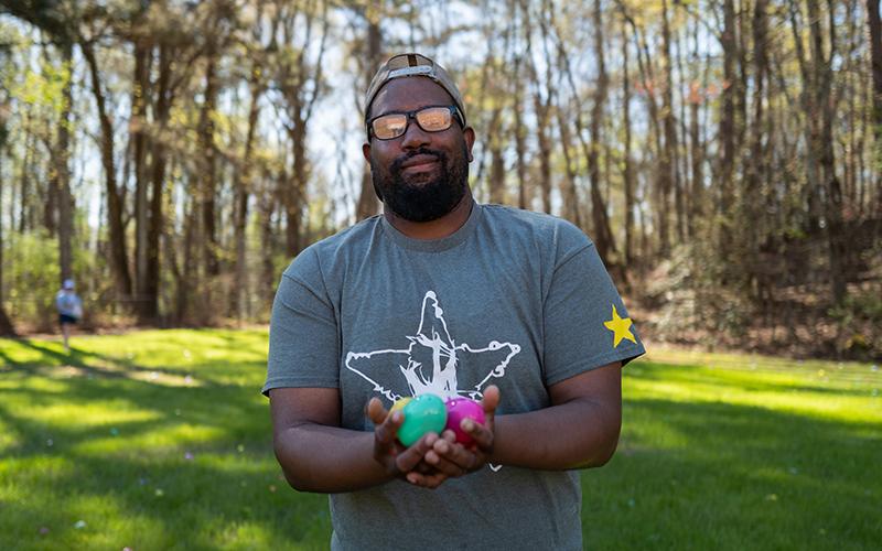Marcus Shackelford holds a handful of eggs as he tosses them out for kids to find at Mt. Carmel Baptist Church. ZACH TAYLOR/Staff
