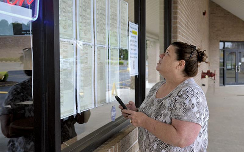 Rena Thompson of Demorest looks at the sample ballots posted on the window of the Habersham County Elections and Voter Registration Office before heading in to vote Monday morning. (Samantha Sinclair/Staff)