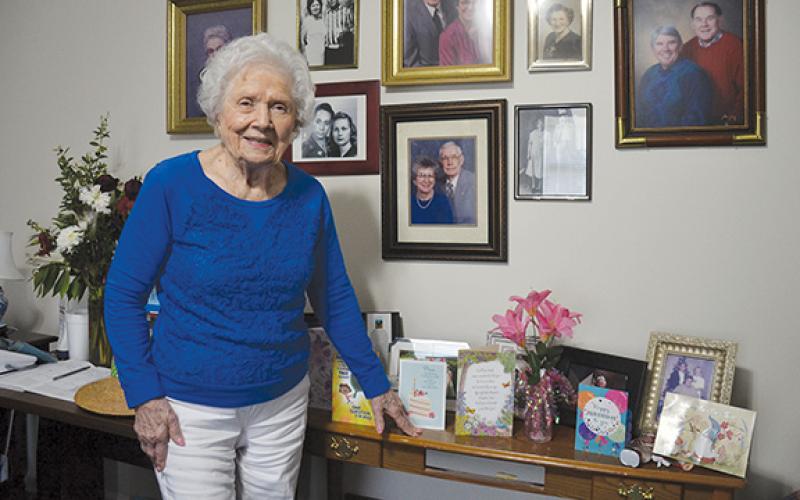 Mary Lou Martin stands in front of family photographs and birthday cards she received. (Samantha Sinclair/Staff)