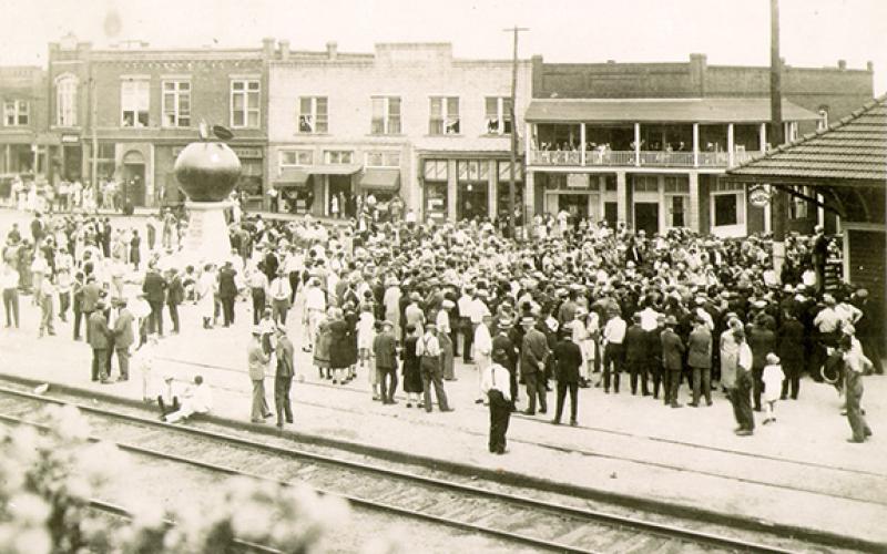 Families gather for the original dedication ceremony for the Big Red Apple 100 years ago. (File)