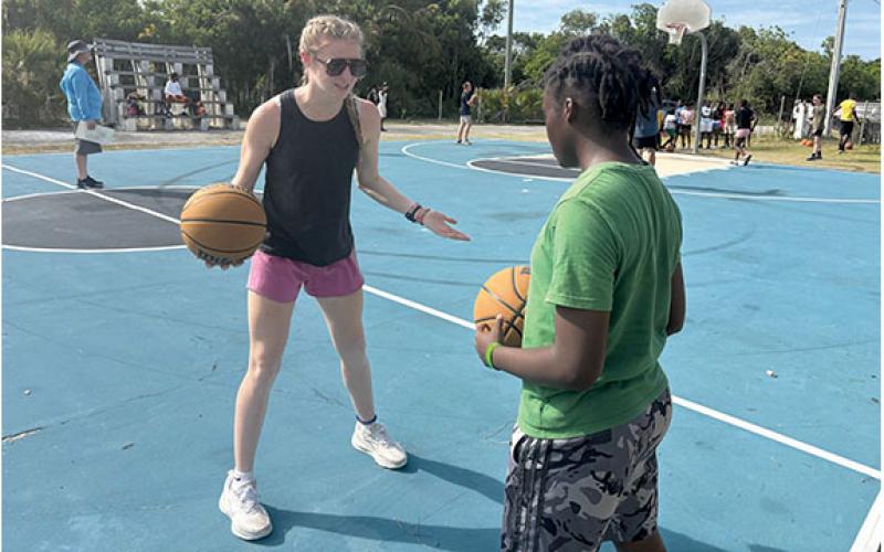 HCHS sophomore Tessa Murdock works one-on-one with a child from the Bahamas. (Callie Cueva/Staff)