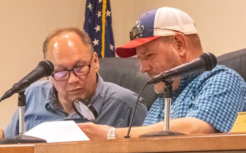From left, Councilman Joe Elam takes a peek through Councilman Erik Keith’s magnifying glass at the newest budget numbers from City Manager Tiera Morrison and Finance Director Angela Adams. (Hannah Caudell/Staff)