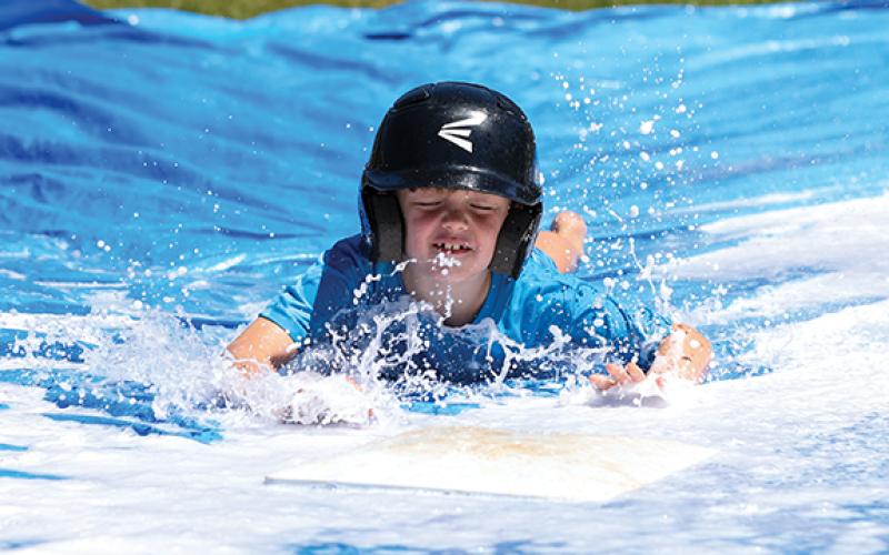 Camper Greyson Kempey slides head first during the TFS baseball summer camp. (Landen Todd/Staff)