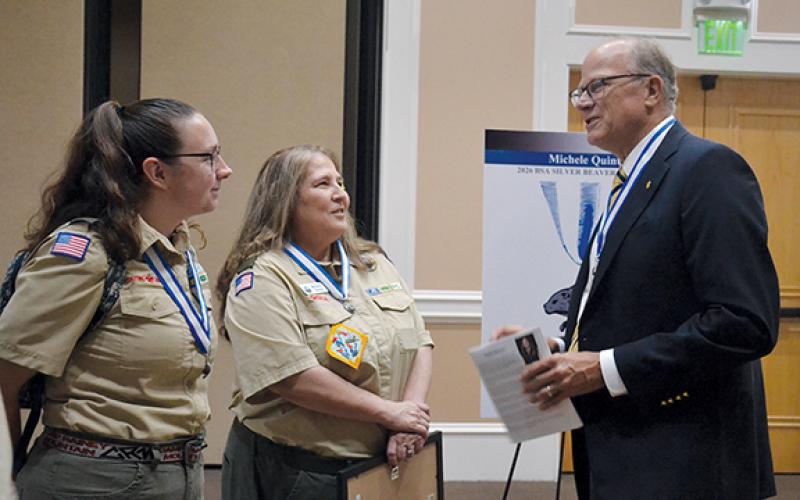 Council President Stewart Swanson (right) congratulates Michele Quintal (center) after the ceremony with Jessica Barnett. Barnett is the Scoutmaster for Troop 5231 in Snellville. (Samantha Sinclair/Staff)