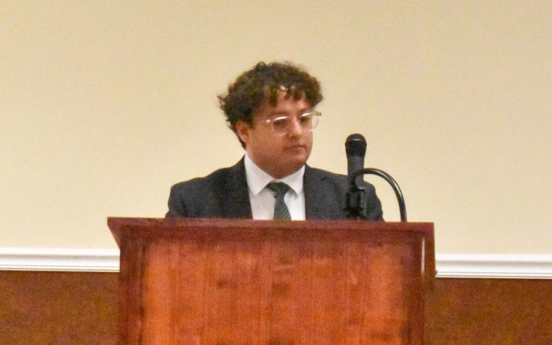 Baldwin City Attorney Sammy Tomasello stands before council to explain the risks associated with moving forward with a Cook Construction petition vote Tuesday night. (Hannah Caudell/Staff)