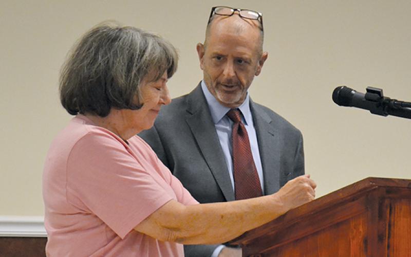 Martha Stuckey speaks about Cook Construction’s treatment of her as Cook Construction Attorney Vince Fitzgerald looks on. (Samantha Sinclair/Staff)