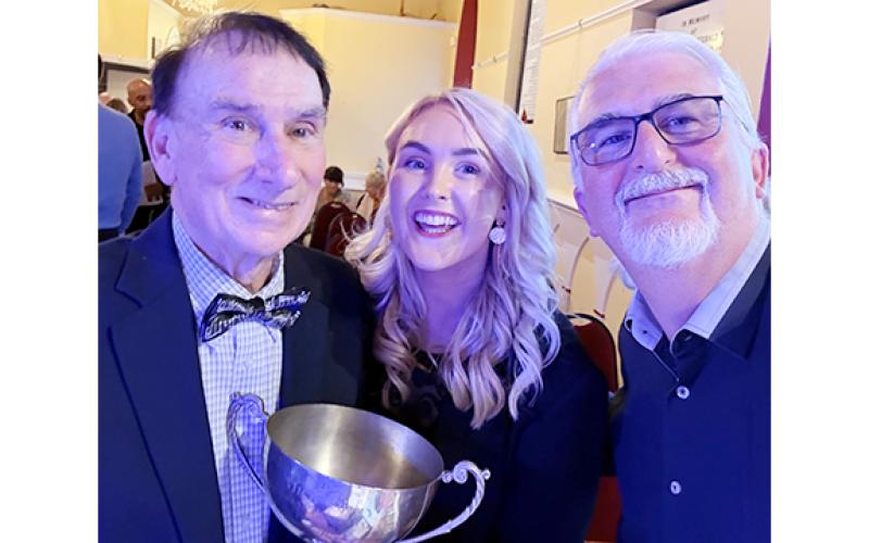 Don Gnecco, Saoirse Scully and Pat Marnane take a photo with the Perpetual Cup after an award-winning performance at the 2026 International Song of Peace contest. (Submitted)