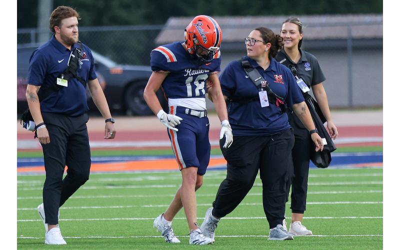 Habersham Central High School athletic trainer Will Bowden (left), Lundon Addison (second from right) and Sydney Lewis, a University of North Georgia athletic training master’s program student, escort Habersham Central football player Creed Jones (center) off the field. (Landen Todd/Staff)