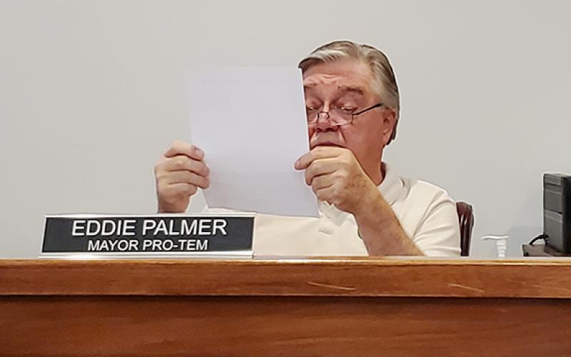Councilman Eddie Palmer reads over Councilman Allen Fox's proposal on limiting the council's compensation during the work session Tuesday night. (Samantha Sinclair/Staff)