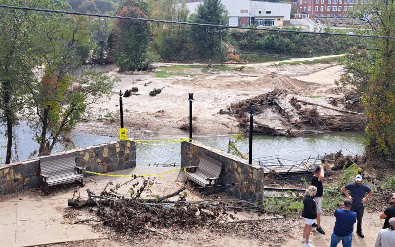 Megan Horn/The Clayton Tribune.  A walking bridge crossing the river in downtown Spruce Pine, N.C., was significantly damaged when Hurricane Helene made its way through the community.