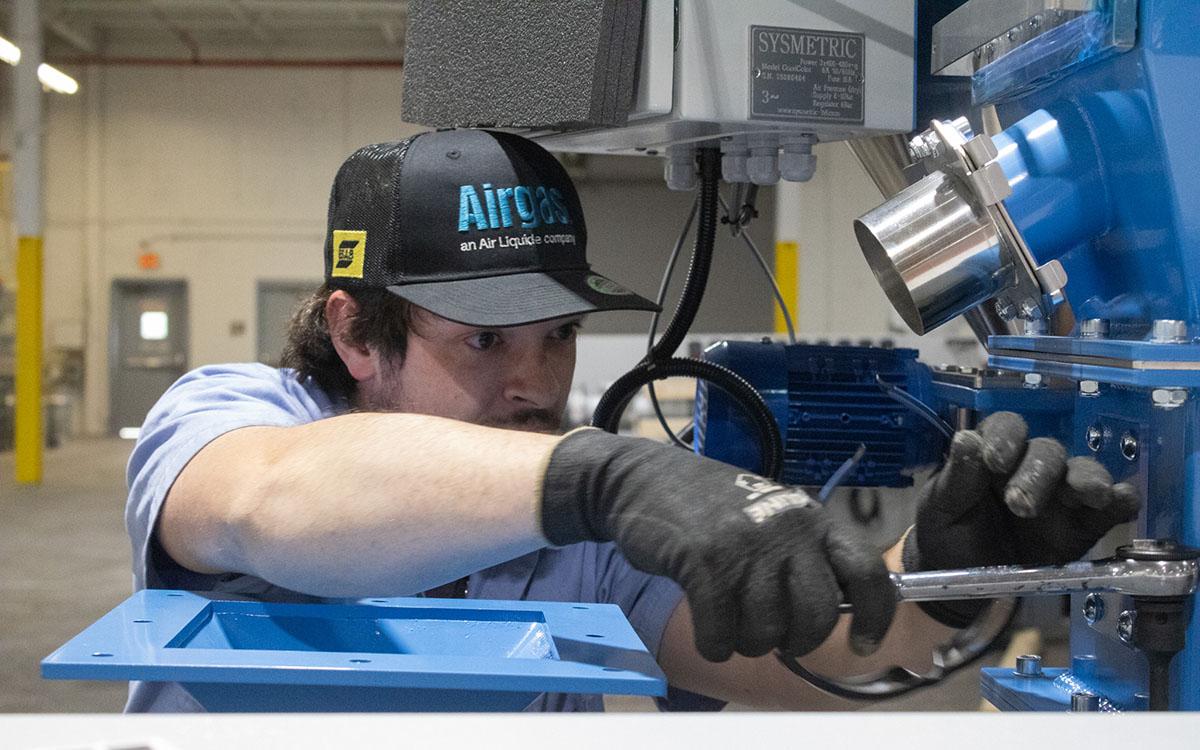 Maintenance Technician Ryan Wade tightens a bolt on new equipment that will eventually help create pipes out of HDPE Pipe Solutions in Alto. (Hannah Caudell/Staff)