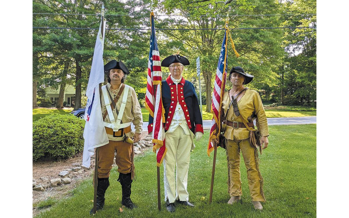 Brent Smith (left) holds the America 250 flag alongside Sons of the American Revolution Joseph Habersham Chapter member Dr. Ed Hendricks (middle) and Lyman Hall Chapter member David Lowden at the Mountain Laurel Festival Parade in Clarkesville. Smith tried to wear what he believed his grandfather would have worn in the war. (Submitted)