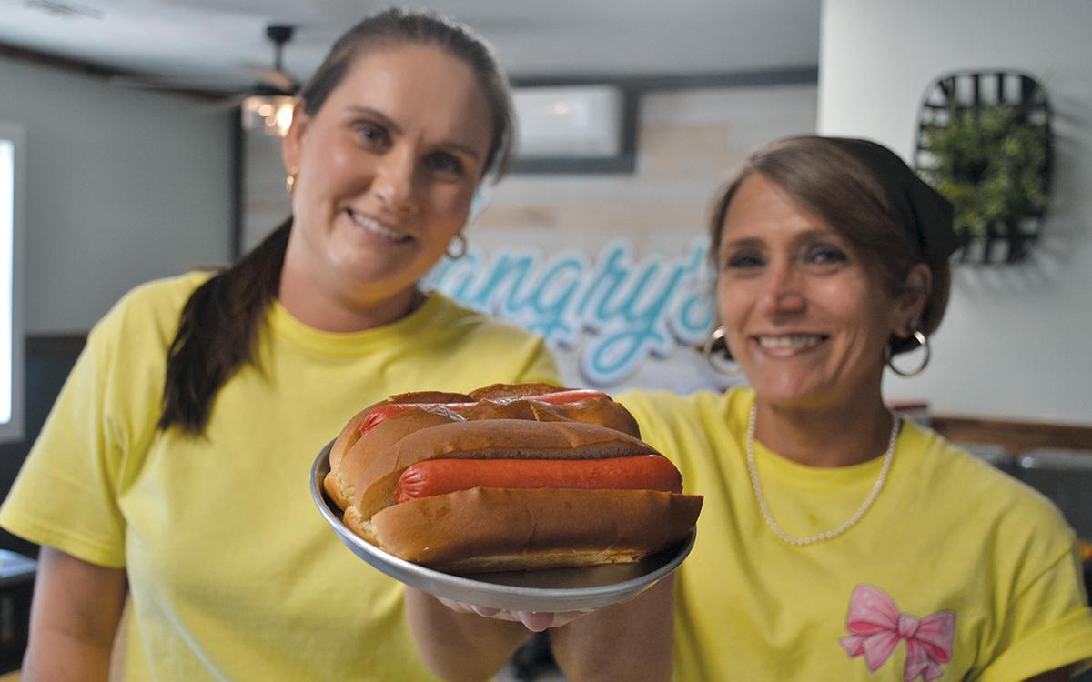 Lauren Bowers and Mandy Brock of Hangry’s Grill show hotdogs similar to those for the Red, White and Tunes hotdog eating contest. (Samantha Sinclair/Staff)