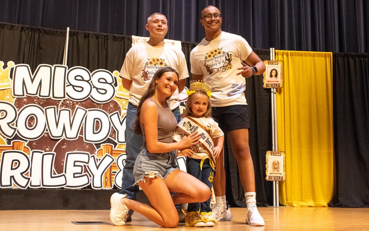 From left, Riley Hembree and A.J. Walker (back row) smile for a photo with Cendall Pitts and her niece, Hadley Powers (front row), one of the mega supreme title holders of the Miss Rowdy Pageant. (Hannah Caudell/Staff)