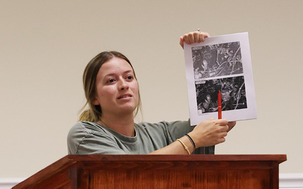 Habersham resident Sydney Blackburn shows Baldwin City Council members a series of maps showing Gainesville's urban sprawl. She explained that she feared the same for Baldwin — and the county in general — with the newly proposed Cook Construction development. (Hannah Caudell/Staff)
