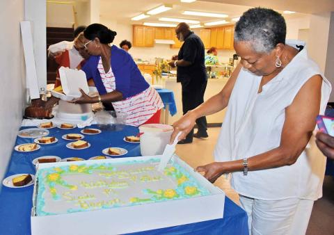 Gwen Brown, daughter of Susie Brown, cuts the cake at Susie Brown’s 100th birthday party earlier this month at a Clarkesville church. (Photo/CHAMIAN CRUZ)