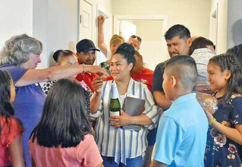 Shown is Habitat for Humanity of Northeast Georgia Executive Director Nanette Baughman reaching over to hug Deyci Rodriguez, surrounded by the rest of the Rodriguez family, who on Sunday were dedicated Habitat’s 71st house. (CHAMIAN CRUZ/Staff)